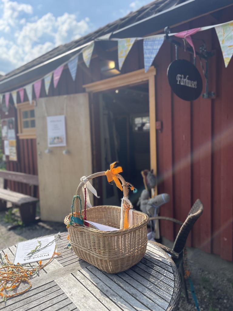 korg på bord framför lite t trähus